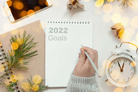 Back to life, goal list concept. Womans hand writing in empty notebook. Resolutions, plan, goals,...