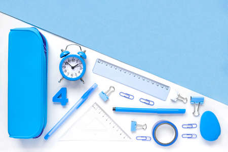 Back to school, business office education concept. Assortment of blue supplies, crayons, clock, pens on a table. Copy space background, top view flat lay overheadの写真素材
