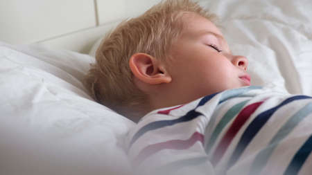 Sleeping Child in Bed. Cute Little Kid Sleeps Sweetly on Cozy White Blanket on its Side. 2 Years Old...