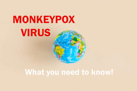 Phrase MONKEYPOX VIRUS what you need to know written on paper with Earth globe. Beige pastel...