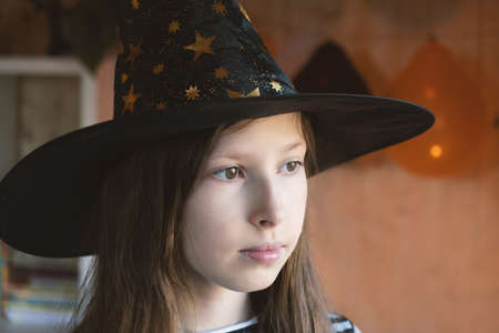 Halloween. Sad pensive girl in witch costume celebrating Halloween. Copy space. Portrait of unhappy...