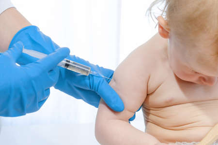 Doctor vaccinating baby in clinic. Little baby get an injection. Pediatrician vaccinating newborn baby. Vaccine for infant child. Child's Immunization, Children's Vaccination, Health concept.の写真素材