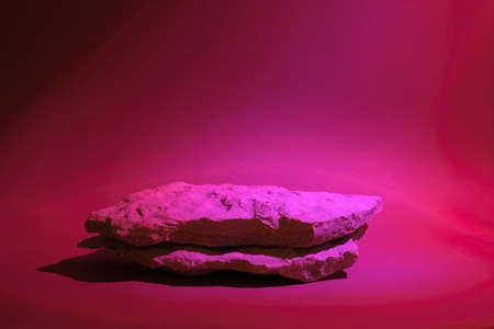 Stone Podium for promotion on holographic neon colored Background. natural rock pedestal. Two stone podiums. beauty product mockup. scene to show products. Show case, display case. front view.の写真素材