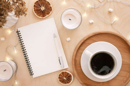 Back to life, goal list concept. Woman's hand writing in empty notebook on wooden table. Resolutions, plan, goals, checklist, idea concept. Top view, flat lay, copy space. 2022. Christmas, New Year.の写真素材