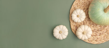 autumn composition. Various pumpkins on olive green Background. Flat lay, top view, copy space. Nordic, hygge, cozy home concept. Thanksgiving fall decoration. Halloween Modern Invitation Mock upの写真素材