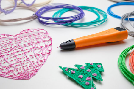 3d pen. Printing with Colored Plastic Wire Filament. Child making a Christmas Three, Heart shape...