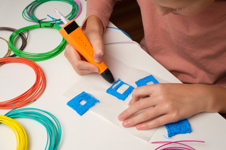 Teen Girl Using 3d Pen. Printing with Colored Plastic Wire Filament. Child making a House, drawing...