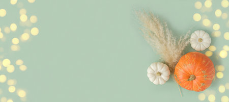 autumn composition. Green desk with pumpkins and dried pampas grass. Flat lay, top view, copy space....