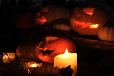 Halloween Pumpkin Head with Carved Scary Smiling Face at Night Outside. Jack-O-Lantern, Burning...