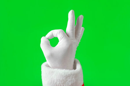 Santa Claus Hands Making Victory Sign and OK Gesture Isolated On Green Background. close up. Christmas Congratulation. Chroma Key Screen. Everything is good. Proposing product. Gestures Packの写真素材