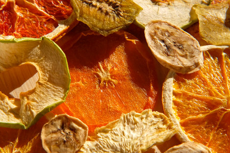 Dried fruits. Assorted of healthy sundried organic fruit flat lay on wooden background. Snacking and baking. Trendy Mix of dried and candied fruit slices. top view, close up. Sunlight hard shadows.の写真素材