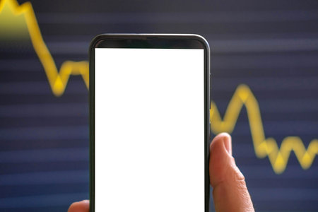 Black phone with blank mockup screen on rising stock graph. Closeup hand showing smartphone isolated green display. Online banking, Fund App use. Financial analyst on Invest Market. bank collapse 2023の写真素材