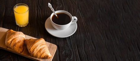 Two croissants on a wooden cutting board. Rustic dark table. food banner. Tasty fresh croissant,...
