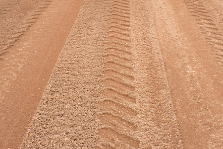 Footprint of car tire tread in a sand gravel road texture. Country road textured background. Backdrop for various ideas. Small stone land. Abstract sandy rough surface. trendy effect. no people. Tireの写真素材