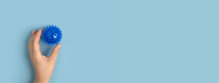 Tactile knobby ball on blue studio background.