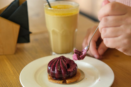 Woman eating delicious fresh blueberry mousse cake. Cutting dessert texture close up. Person taking...
