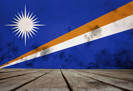 The flag of Marshall Islands on the wall of plaster and the wooden floor.の写真素材