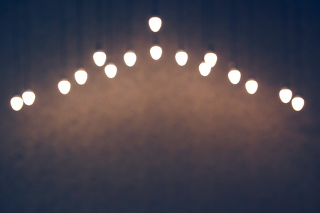 Blurred texture of many light bulbs on a dark background.の写真素材