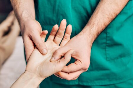 Wrist massage. A male massage therapist puts pressure on a sensitive point on a hand.