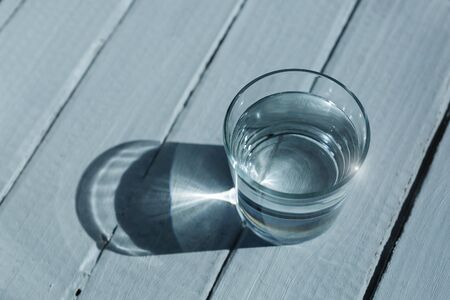 A glass with clean drinking water on a blue background.の写真素材