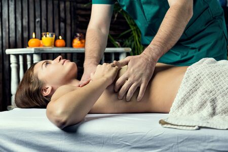 Hands of a massage therapist are doing chest massage to a woman.の写真素材