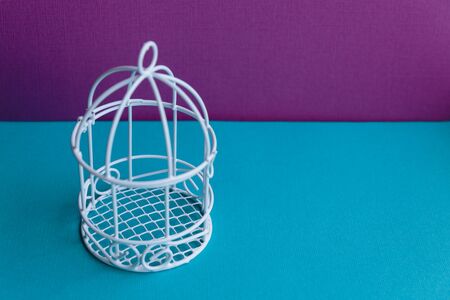 Small white decorative cage for interior decoration on a blue background.の写真素材