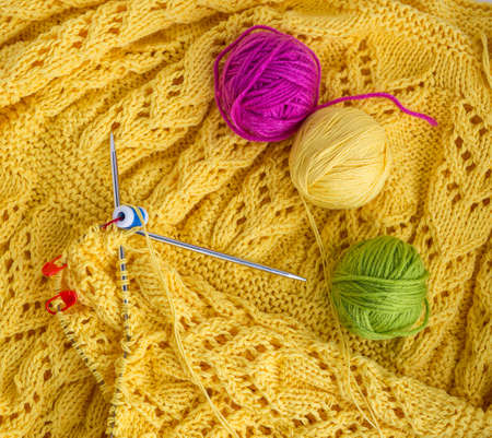 Yellow knitted texture, pigtails and tracery. Pink, green and yellow balls