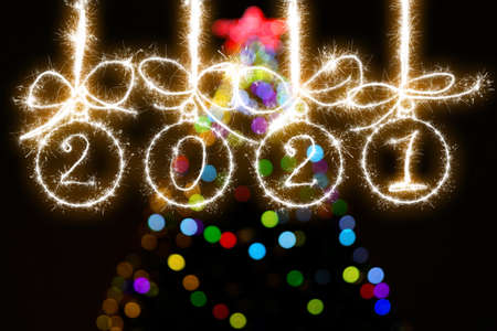 Christmas balls made of sparklers and the inscription 2021against the background of multi-colored...