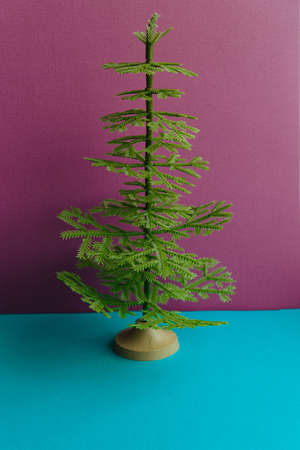Miserable scanty plastic spruce on a pink background.