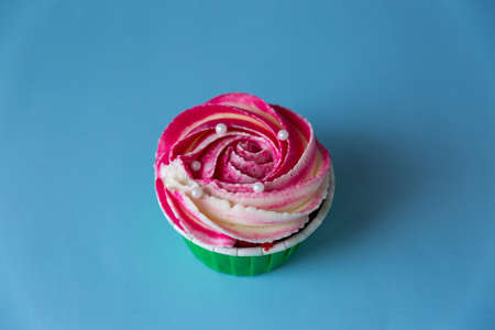 Appetizing cupcake with pink cream in the center on a light blue backgroundの写真素材