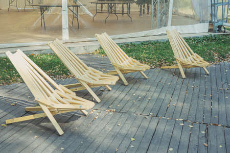 Four empty wooden deck chairs in the gardenの写真素材