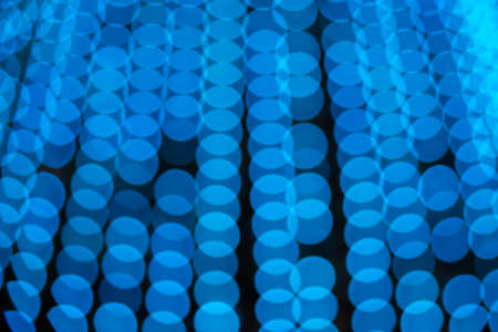 Abstract blurred bokeh texture from a variety of blue circles, burning light bulbs, christmas lightsの写真素材