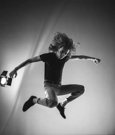 Black and white photo of a frantic and expressive jump, hair scatter in different directions....