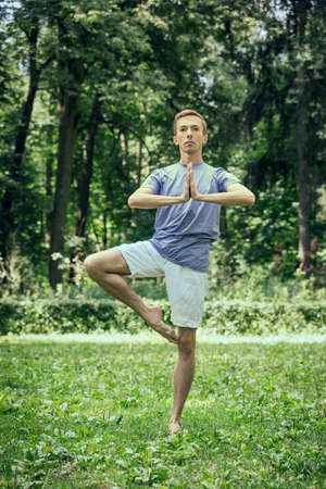 Fitness, man training yoga in tree pose in park.の写真素材