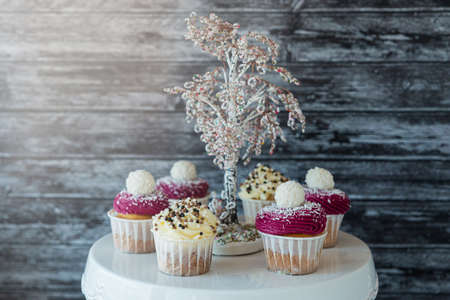 delicious cupcakes with white cream decorated with ripe strawberries on a gray blue background