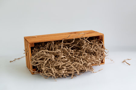 Wooden box with wrapping kraft paper for gifts on a white background.