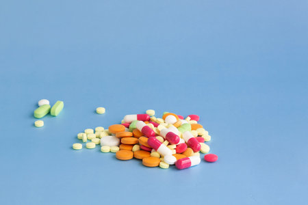 A slide of multi-colored pills on a blue background.の写真素材