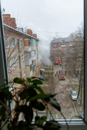 City Tula. Russia - December 01, 2020: Smoke during a fire in a multi-storey building. A fire truck...