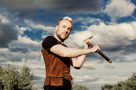 A young man with an interesting depicts a Viking with an ax in an unreliable stylized modern costumeの写真素材