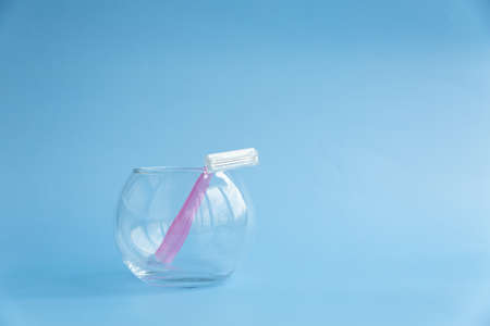 Disposable razor in a transparent jar on a blue backgroundの写真素材