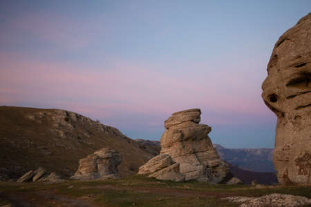 Evening mountain landscape, sunset purple sky between large boulders