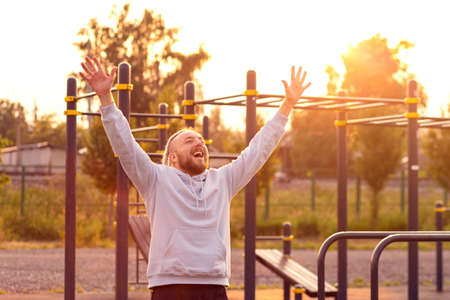 In the morning at sunrise, a man with an interesting braid hairstyle triumphantly raised his hands...