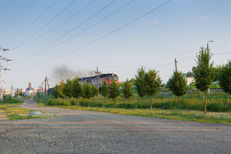 City Tula. Russia - July 11, 2021: a huge new powerful diesel locomotive carries a freight train of wagons along a railway line in the rays of a summer sunriseのeditorial素材