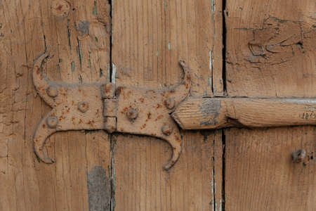 Antique curly hinges on old shutters.