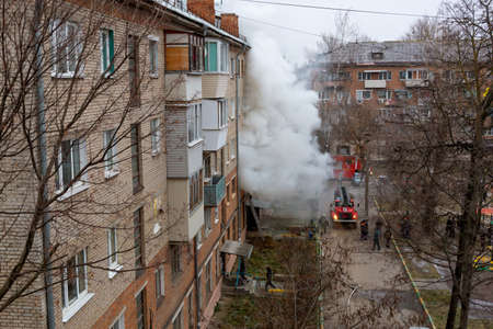 City Tula. Russia - December 01, 2020: Smoke during a fire in a multi-storey building. A fire truck and firemen arrived to eliminate the dangerous fire.のeditorial素材
