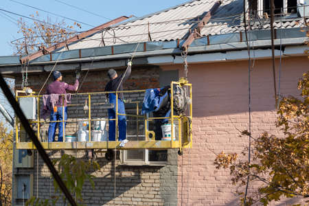 City Tula. Russia - October, 08, 2021 A mans house painters paint a residential building on a front liftのeditorial素材