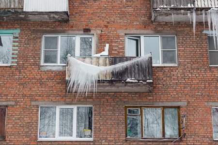 Russia. Terrible huge icicles formed on the balcony of a multi-storey building due to a poor roof storm system.の写真素材