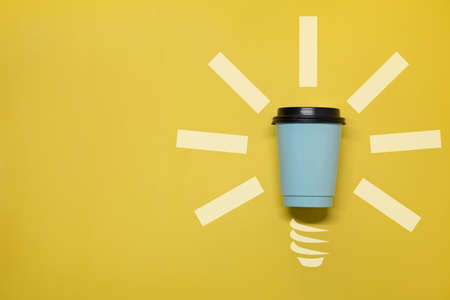 Paper cup with coffee on a yellow background on the right. Great idea