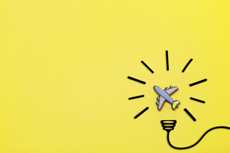 Idea symbol in the form of a painted light bulb with Toy airplane inside on a yellow background. Time to travel.の写真素材