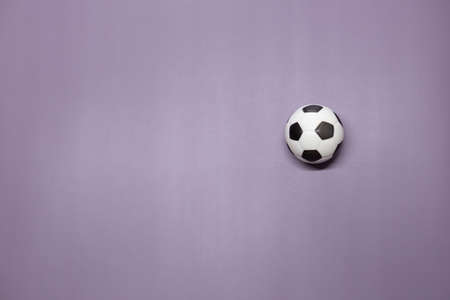 A soccer ball inside on a purple background